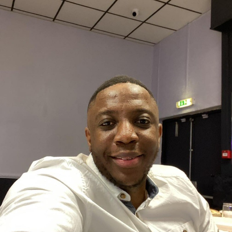 Person smiling indoors, wearing a white shirt, participating in the Executive Leadership & Management Skills Training Program 2025.