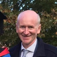 Smiling individual in suit outdoors during Executive Leadership & Management Skills Training Program 2025